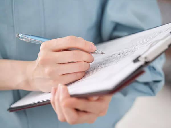 A person writing on a clipboard